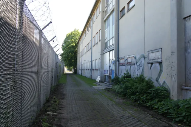 Berlin Cité Pasteur: ehem. französisches Gymnasium am Schutzzaun des Flughafen Tegel